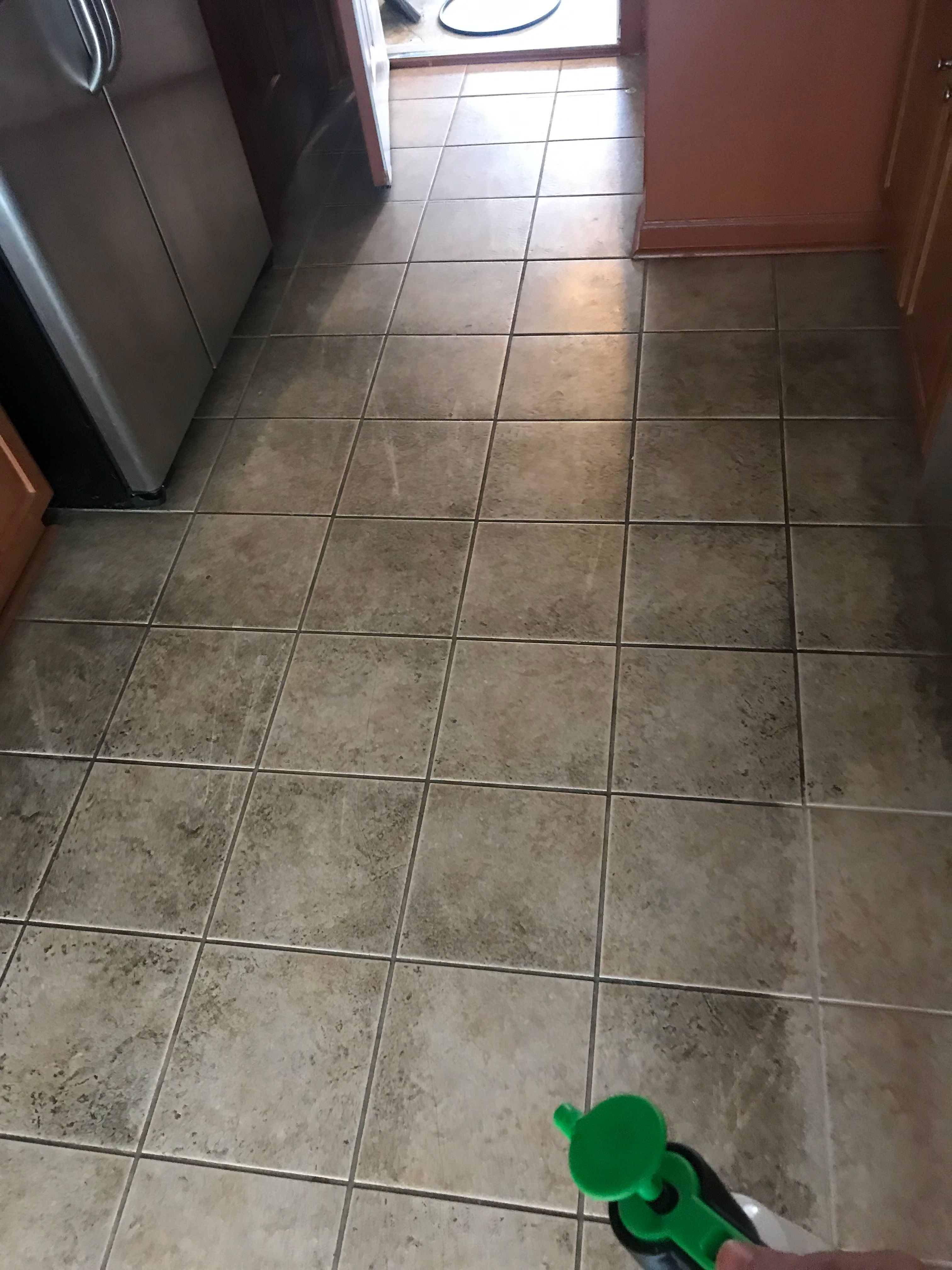 Tile floor being cleaned, with grout lines visibly brightened
